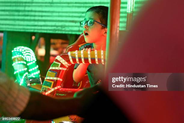 Child enjoys joyride at Mahim Fair on December 7, 2017 in Mumbai, India. Located at burial of Makhtoom Fakir Ali Paru , a famous Qazi of Mahim, This...