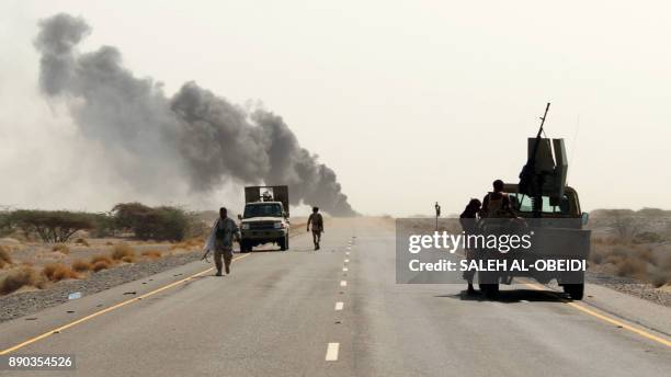 Yemeni fighters loyal to the Saudi-backed Yemeni president are seen with their vehicles on the road leading to the town of Khokha which was retaken...