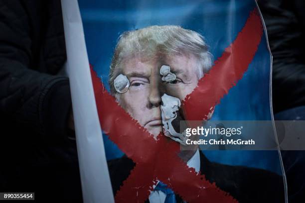 Protesters burn a poster of U.S. President Donald Trump in front of the Damascus Gate at the entrance to the Old City on December 11, 2017 in...