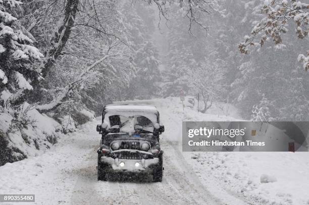 Vehicle drives past a snow-covered Gulmarg Tangmarg road on December 11, 2017 about 38 kilometers from Srinagar, India.
