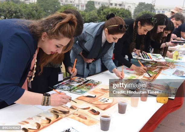 Artists painting Delhi tourist spots during 75 meter long live World Record Live Watercolor Painting at Central Park, Connaught Place on December 11,...