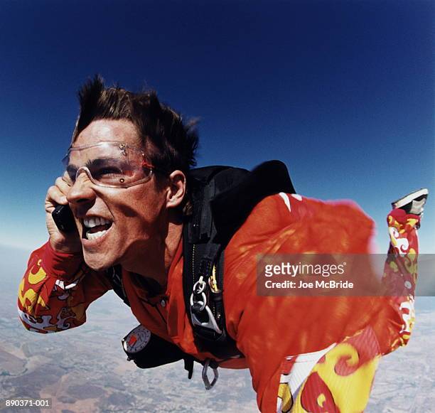 man using mobile phone while sky diving - paraquedas - fotografias e filmes do acervo