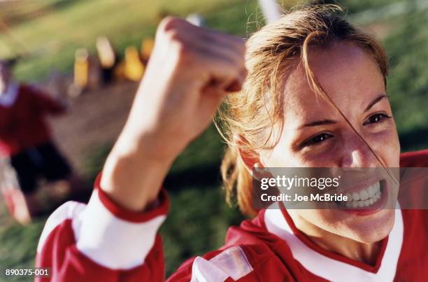 young female soccer player cheering - clenching teeth stock-fotos und bilder