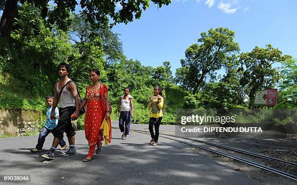 An Indian family walks towards their home village Kurseong on the deserted National Highway 55 at Tindharia, some 40 kms from the eastern Indian city...