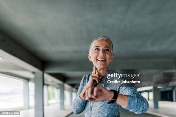 pulso de teniendo mujeres corredor - taking pulse fotografías e imágenes de stock