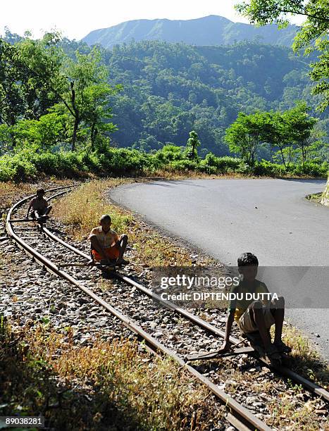 Indian children use handmade trolleys to ride the toy train railway track on deserted National Highway 55 at Tindharia, some 40 kms from the eastern...