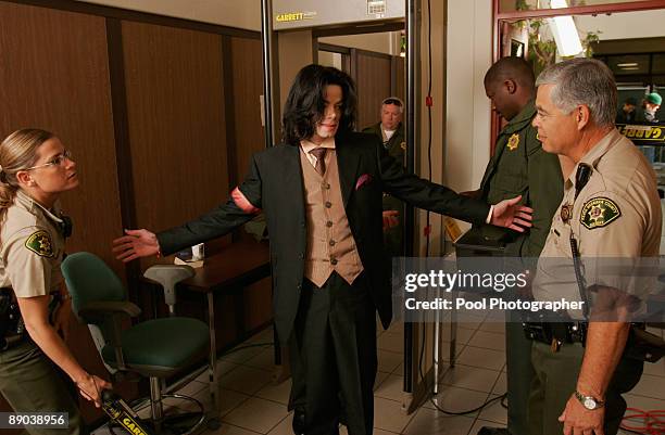 Sheriff deputies scan Michael Jackson with metal detectors as he passes through a security checkpoint upon arriving for his child molestation trial...