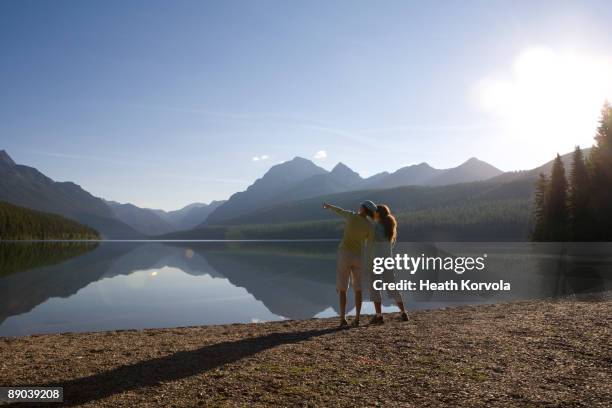 two ladies looking over calm quiet alpine lake. - lake whitefish stock pictures, royalty-free photos & images