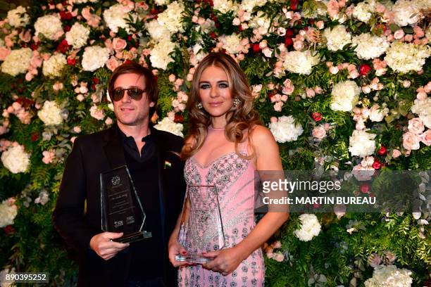 French singer Thomas Dutronc and British actress Liz Hurley pose in Paris on December 11, 2017 during a charity dinner in honour of Indian...