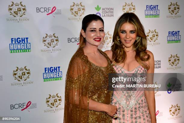 Indian billionaire Sudha Reddy poses with British actress Liz Hurley during a photocall in Paris on December 11, 2017 during a charity dinner in...