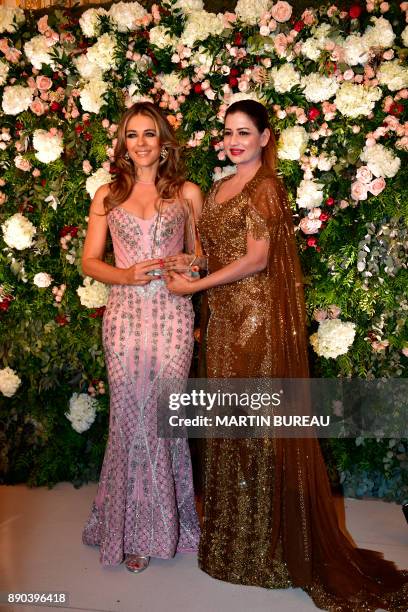 Indian billionaire Sudha Reddy poses with British actress Liz Hurley in Paris on December 11, 2017 during a charity dinner in Reddy's honour after...