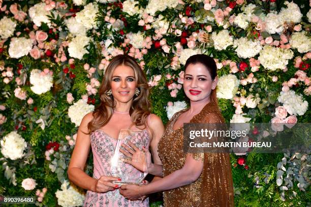 Indian billionaire Sudha Reddy poses with British actress Liz Hurley in Paris on December 11, 2017 during a charity dinner in Reddy's honour after...