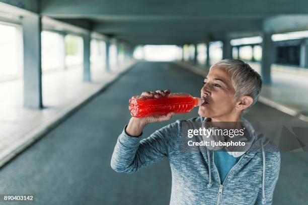 schöner athlet, ruhen sie sich nach hartem training - energydrink stock-fotos und bilder