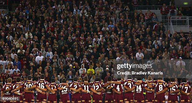 Maroons players embrace for the national anthem shortly before game three of the ARL State of Origin series between the Queensland Maroons and the...