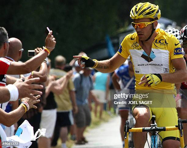 Yellow jersey of overall leader, French cycling team AG2R-La Mondiale 's Rinaldo Nocentini, throws his feeding bag to members of the public as he...