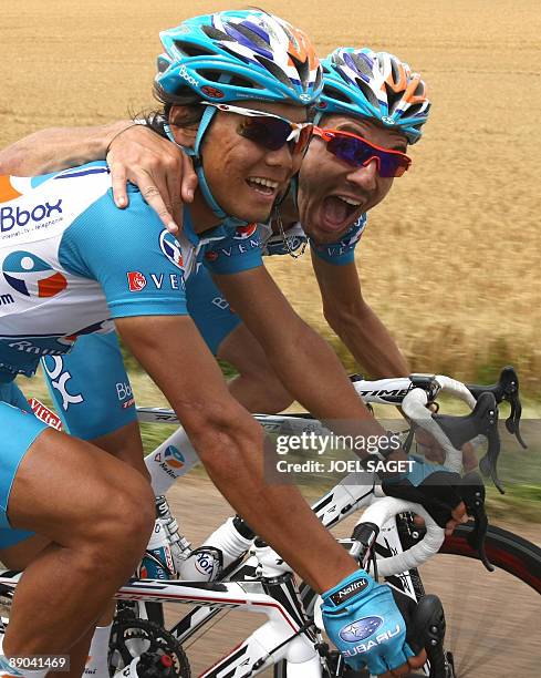 French cycling team BBOX Bouygues Telecom 's rider Yukiya Arashiro of Japan shares a laugh with a teammate as he rides in the pack on July 15, 2009...