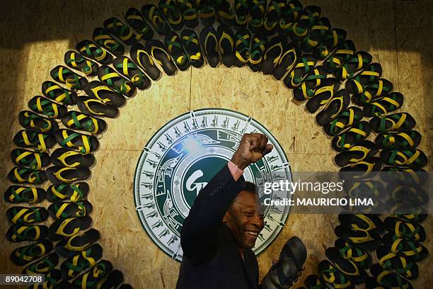 Brazilian soccer legend Pele poses for photographers as he presents an ecological sandal made with recycled materials from tyre remains, during a...