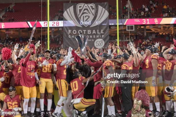 The USC Trojans hold the Pac-12 Championship trophy aloft while celebrating winning the Pac-12 Championship game against the Stanford Cardinal on...