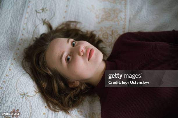 portrait of young woman lying on bed. - no make up - fotografias e filmes do acervo