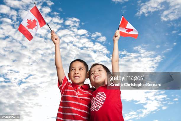 young sibling celebrating canada day - canada day stock pictures, royalty-free photos & images