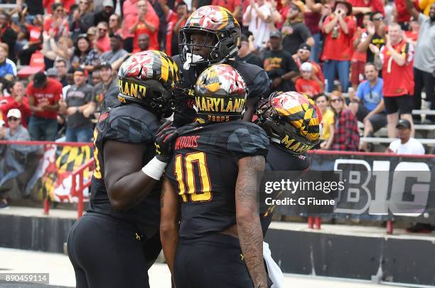 Darnell Savage Jr. #4 of the Maryland Terrapins celebrates with teammates after returning an interception for a touchdown against the Towson Tigers...