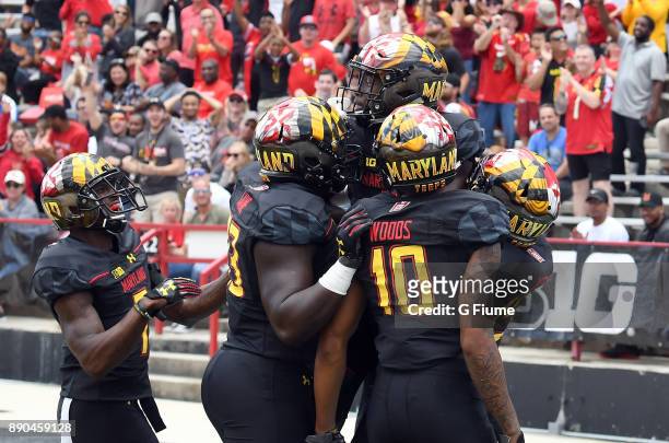 Darnell Savage Jr. #4 of the Maryland Terrapins celebrates with teammates after returning an interception for a touchdown against the Towson Tigers...