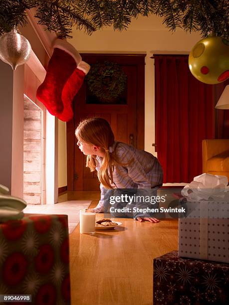 young girl looking up chimney for santa claus - hanging christmas lights stock pictures, royalty-free photos & images