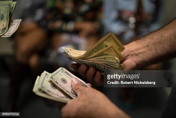 Police officers with the Los Angeles Police Department's vice squad count the cash found with the 13 women arrested earlier in the day at the South...