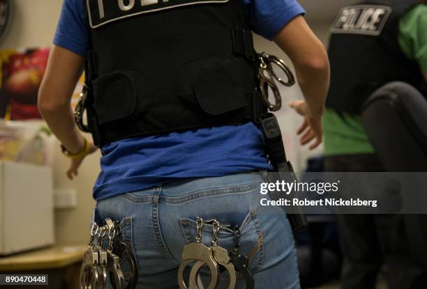 An officer of the Los Angeles Police Department's vice squad gathers handcuffs before transporting 13 prostitutes to jail May 18, 2017 in the...