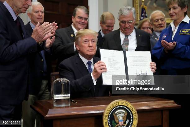 President Donald Trump holds up 'Space Policy Directive 1' after signing it during a ceremony with NASA astronauts Peggy Whitson, Buzz Aldrin and...