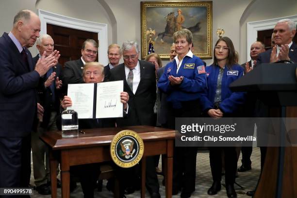 President Donald Trump holds up 'Space Policy Directive 1' after signing it during a ceremony with Vice President Mike Pence, Sen. Bill Nelson and...