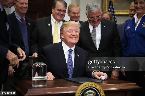 President Donald Trump smiles after signing 'Space Policy Directive 1' during a cereomny in the Roosevelt Room at the White House December 11, 2017...