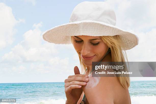 woman putting suntan lotion on - putting lotion stock pictures, royalty-free photos & images