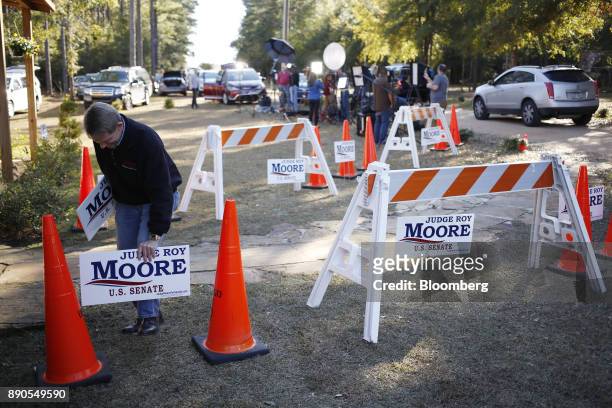 Volunteer places campaign signs in the ground ahead of a rally for Roy Moore, Republican candidate for U.S. Senate from Alabama, in Midland City,...