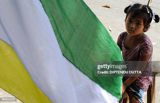 An Indian child looks on next to Gorkha People's Liberation Front flags on the blocked National Highway 55 in Salbari village on the outskirts of...