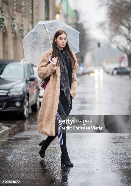Model Julia Leineweber under an umbrella wearing a H&M teddy coat, Mango bag, Adidas jogger pants, Zara sweater, H&M boots, Gucci scarf on December...