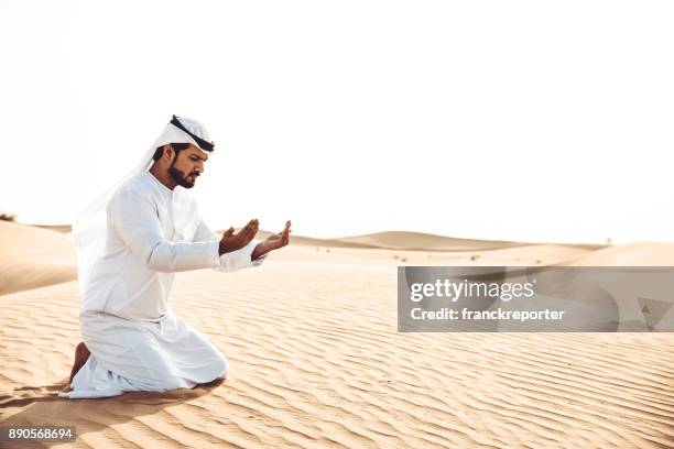 arabic man praying in the desert - agal stock pictures, royalty-free photos & images