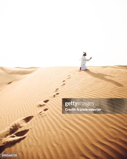 arabic man praying in the desert - agal stock pictures, royalty-free photos & images