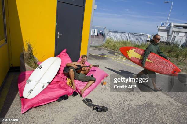 Kite-surfer carries his surf inside the 'surfers-village' at Schevenigen beach, near The Hague, on July 16, 2009. The village, created by the...