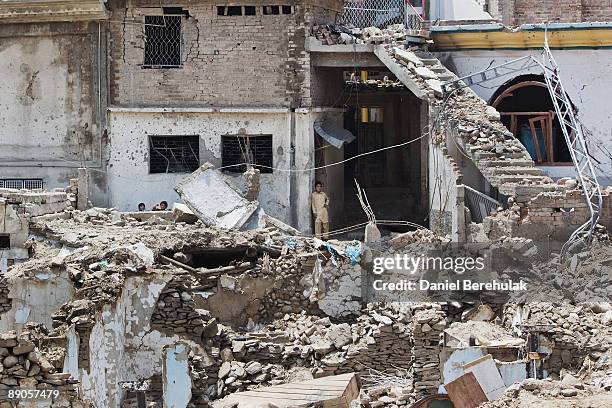 Young Pakistani IDPs play in front of their damaged house after returning to their village of Sultanwas on July 16, 2009 near Dagar in Buner,...