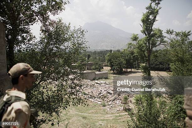 Member of the Pakistan Military passes destroyed homes while moving through the village of Sultanwason July 16, 2009 near Dagar in Buner, Pakistan....