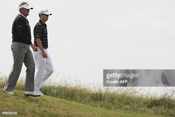 Golfer Zach Johnson and Scottish golfer Colin Montgomerie walk to the 7th fairway on the first day of the 138th British Open Championship at...