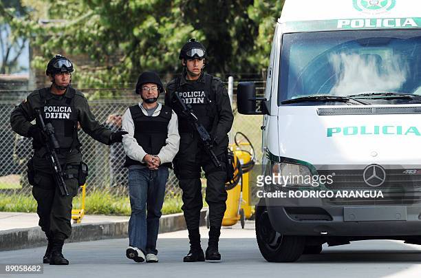 Colombian police officers escort Revolutionary Armed Forces of Colombia member Gerardo Aguilar , a.k.a "Cesar", before being extradited to the US, at...