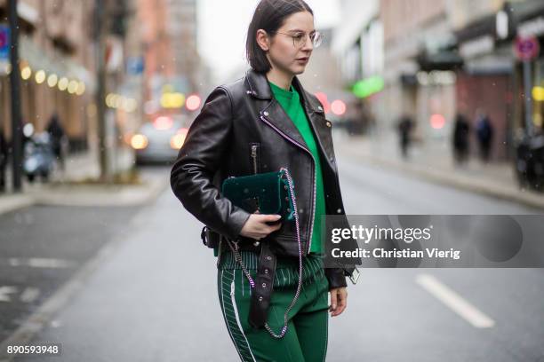 Maria Barteczko wearing black biker leather jacket Acne, glasses, green cashmere sweater Valentino, green jersey track pants Valentino, silver...