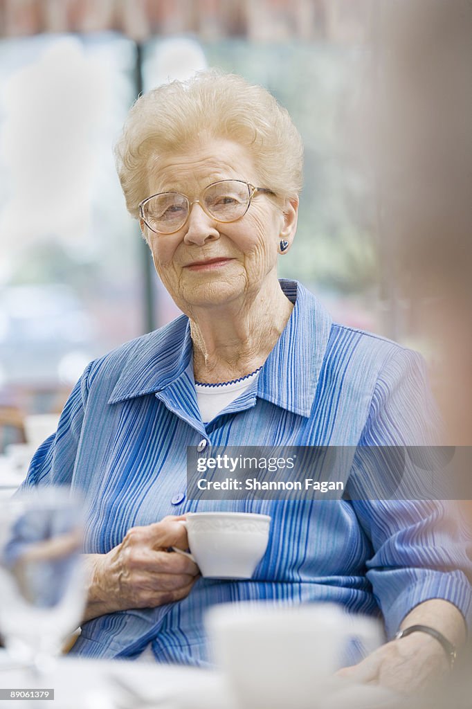 Elderly Woman Sipping Coffee in Nursing Home