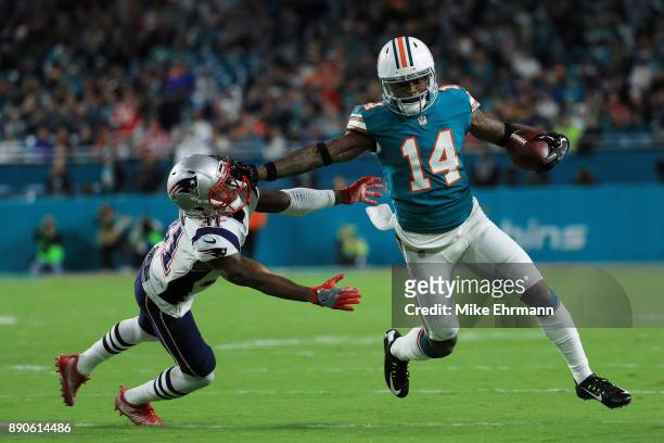 Jarvis Landry of the Miami Dolphins tries to avoid the tackle of Jonathan Jones of the New England Patriots in the first quarter at Hard Rock Stadium...