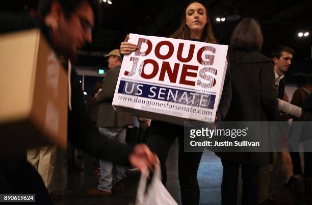 Campaign workers prepare to hand out signs during a get out the vote campaign rally for democratic Senatorial candidate Doug Jones on December 11,...
