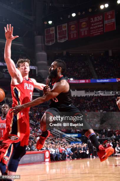 James Harden of the Houston Rockets passes the ball against Omer Asik of the New Orleans Pelicans on December 11, 2017 at the Toyota Center in...