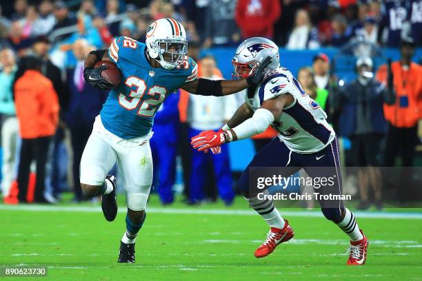 Kenyan Drake of the Miami Dolphins tries to avoid the tackle by Elandon Roberts of the New England Patriots during the first quarter at Hard Rock...
