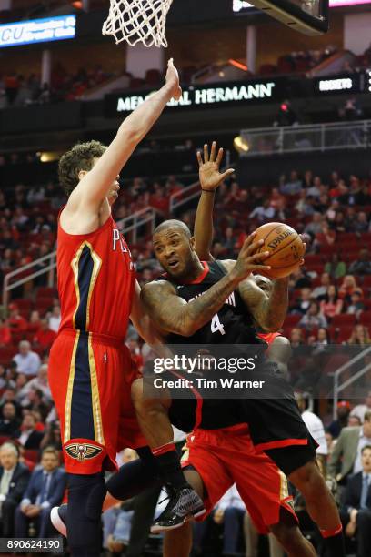 Tucker of the Houston Rockets drives to the basket defended by Omer Asik of the New Orleans Pelicans Jalen Jones in the first half at Toyota Center...